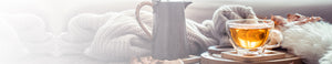 FAQs hero -- tea mug with tea, tea kettle, sweater, and leaves