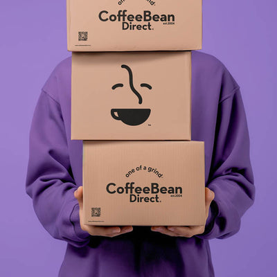 Coffee Bean Direct Roaster's Blend 12-Month Gift Subscription -- customer holding 3 Coffee Bean Direct delivery boxes with coffee