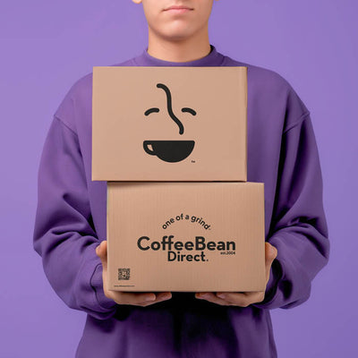 Coffee Bean Direct Roaster's Blend 6-Month Gift Subscription -- customer holding 2 Coffee Bean Direct delivery boxes with coffee