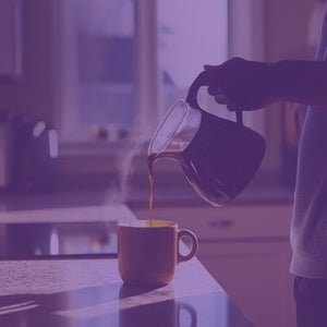 Ethiopian Yirgacheffe featured mobile hero -- person pouring coffee from a pot into a mug on a kitchen table, with a bag of Coffee Bean Direct coffee nearby
