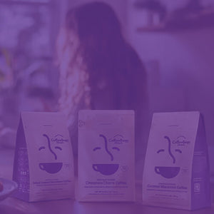 Sweet Treats Gift Bundle featured mobile hero -- assorted Coffee Bean Direct bags on kitchen table alongside mug of coffee and plate of snacks
