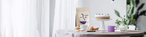 Anniversary Blend featured hero -- table containing bag of Coffee Bean Direct coffee, assorted pastries, cake, and a coffee mug