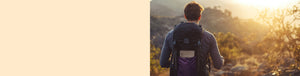 Single Origin Dark and Medium Subscription featured hero -- hiker with backpack containing a 1lb bag of Coffee Bean Direct coffee