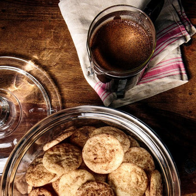 Coffee Bean Direct Cookiedoodle flavored coffee -- French Press with coffee on a table alongside cookies in a glass bowl