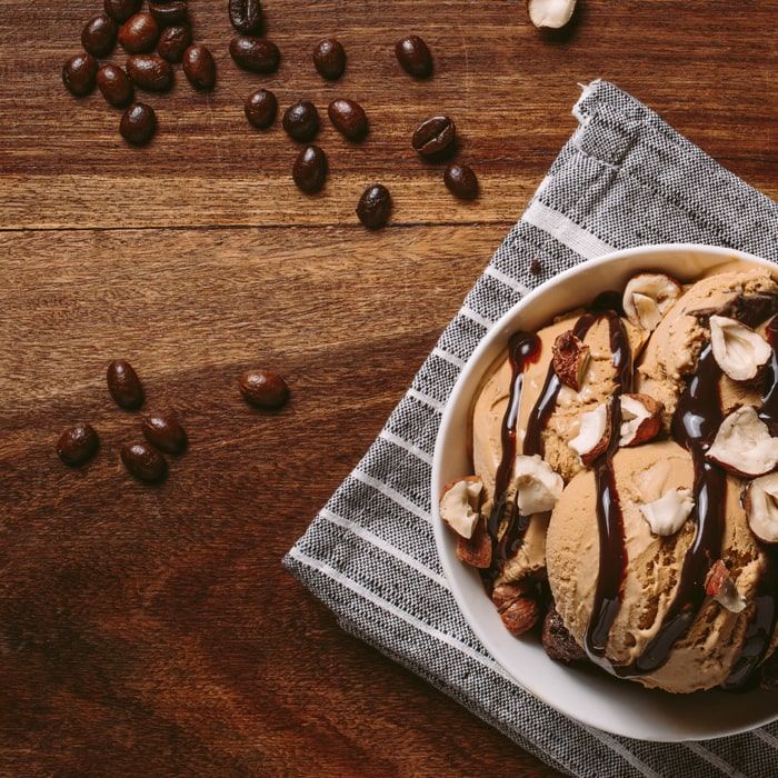 Coffee Bean Direct Sinful Delight flavored coffee -- bowl of ice cream with shaved hazelnuts and chocolate syrup alongside scattered coffee beans